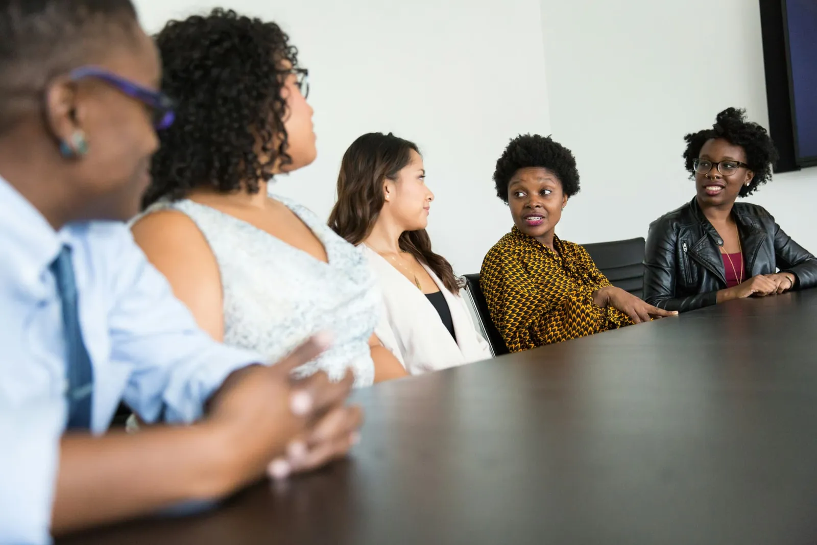Group of Black women collaborating around a conference table.